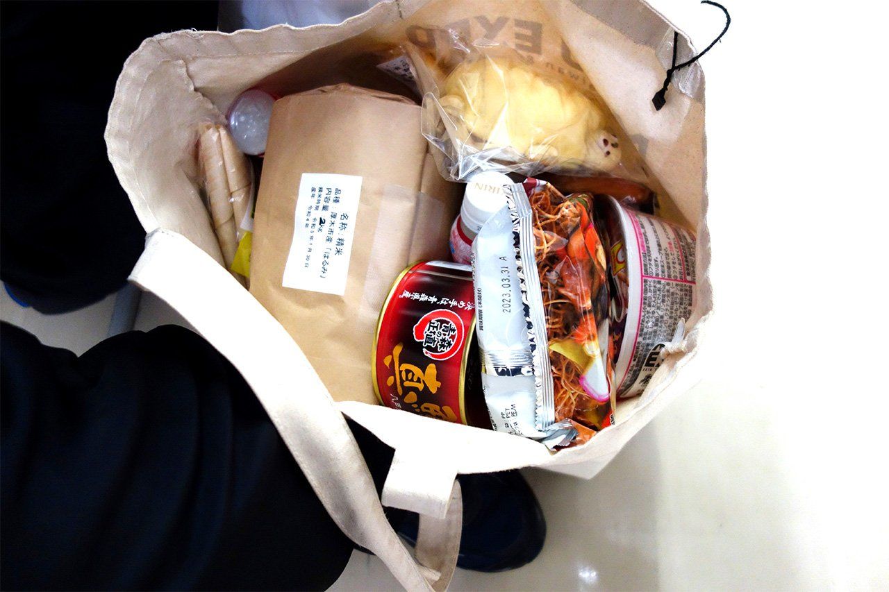 Cet étudiant nous montre ce qu’il a mis dans son sac ; pour lui, des « produits nécessaires ». (© Nippon.com)