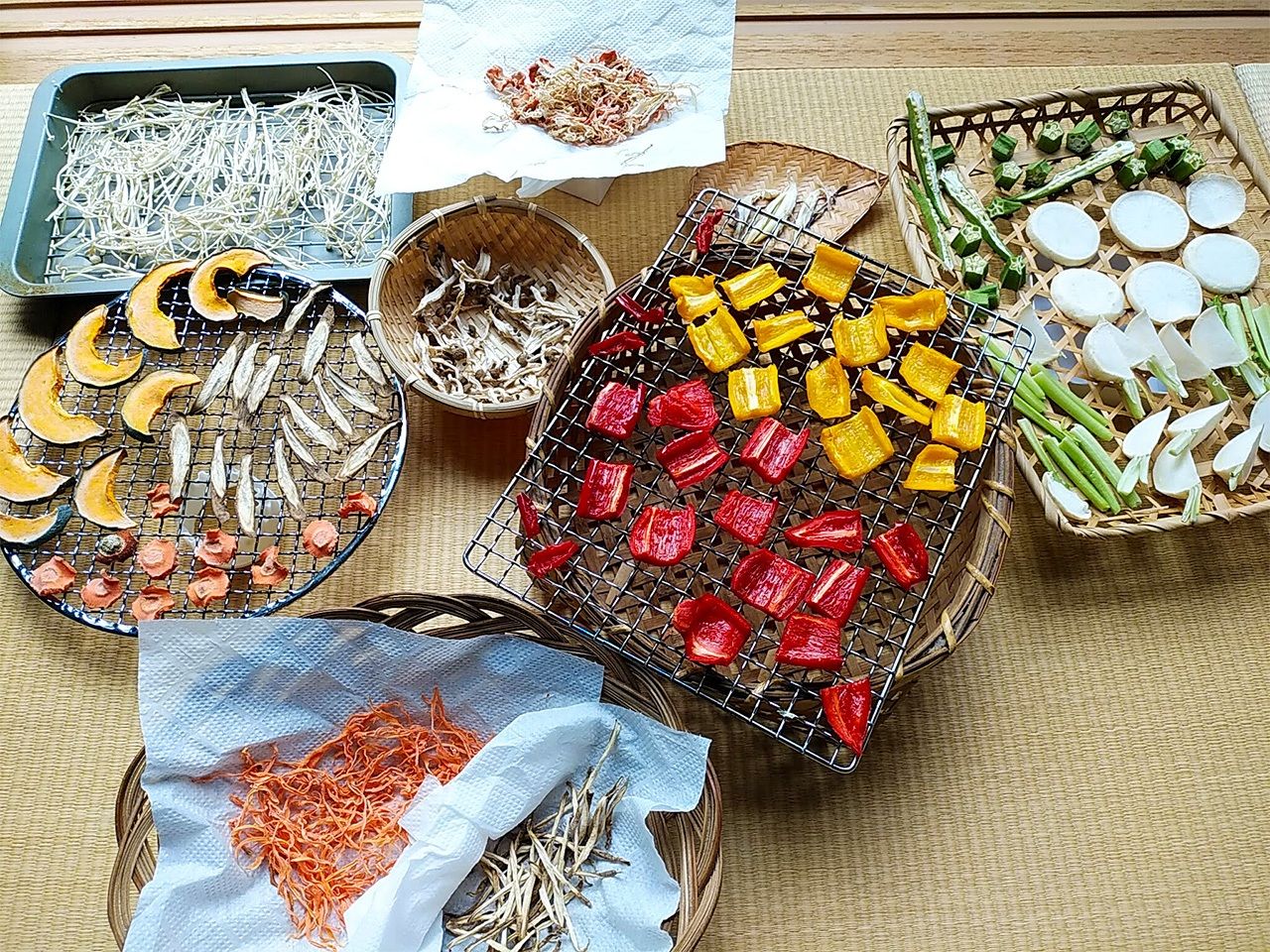 La préparation des kanbutsu peut aussi se faire à l’intérieur. En haut à partir de la gauche : champignons enoki, mélange de carottes et de daikon ; au milieu à gauche : citrouille, carottes et bardane ; champignons shimeji ; bulbes de gingembre myôga. En diagonale du bas vers la droite : carottes et bardane ; poivrons ; tranches de navet et okra.