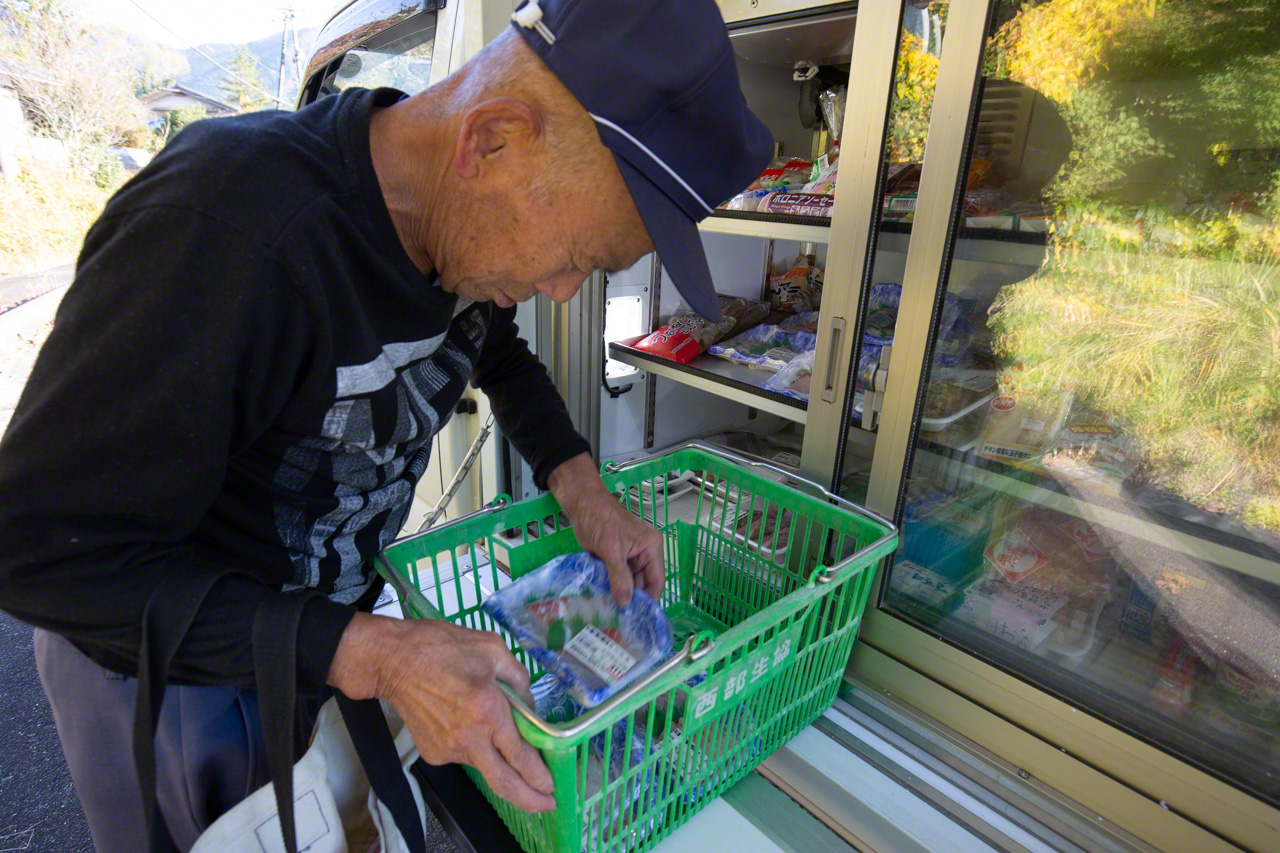 Un homme met avec enthousiasme des barquettes de sashimis dans son panier. &laquo;&nbsp;J'attends toujours avec impatience la visite du camion&nbsp;&raquo;, dit-il.