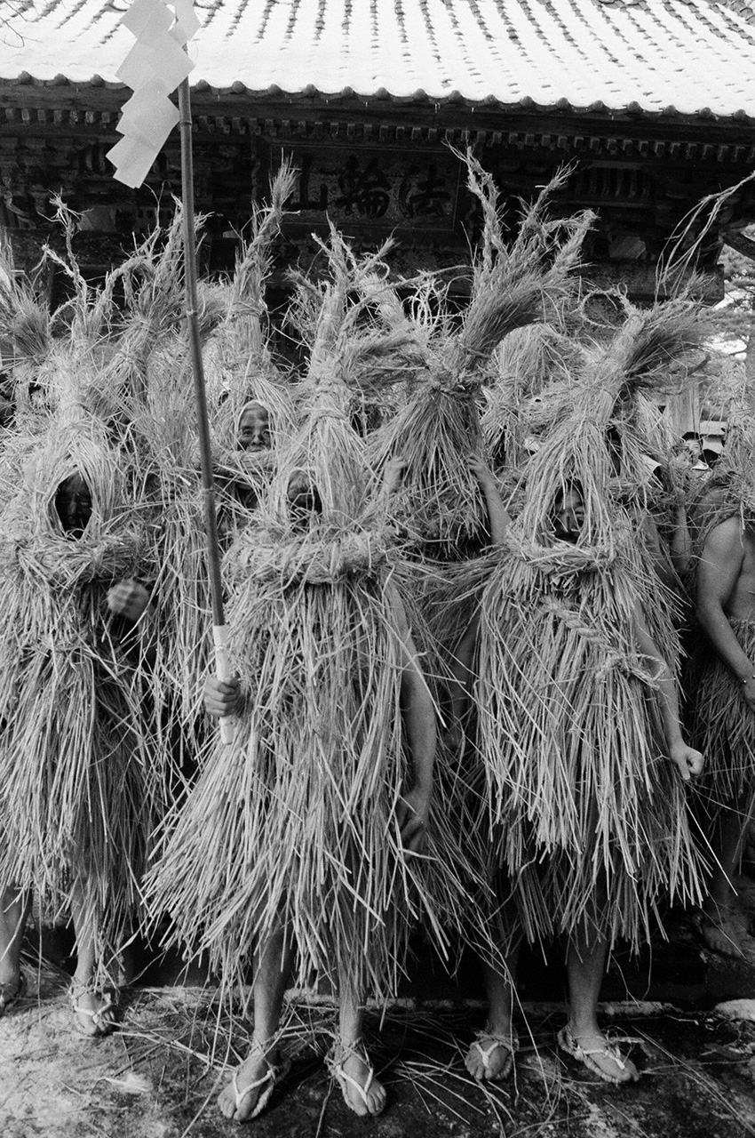 Hibuse no tsukai : v&ecirc;tus de costumes de paille, les hommes qui d&eacute;marrent une ann&eacute;e n&eacute;faste, appel&eacute;e yaku-doshi, portent des b&acirc;tons gohei d&eacute;cor&eacute;s de guirlandes en papier. Ils poussent d'&eacute;tranges cris en d&eacute;filant dans les rues de la ville qu&rsquo;ils aspergent d&rsquo;eau. Ce sont des &eacute;missaires des divinit&eacute;s. Pr&eacute;fecture de Miyagi, 1996. (&copy; Haga Hideo)