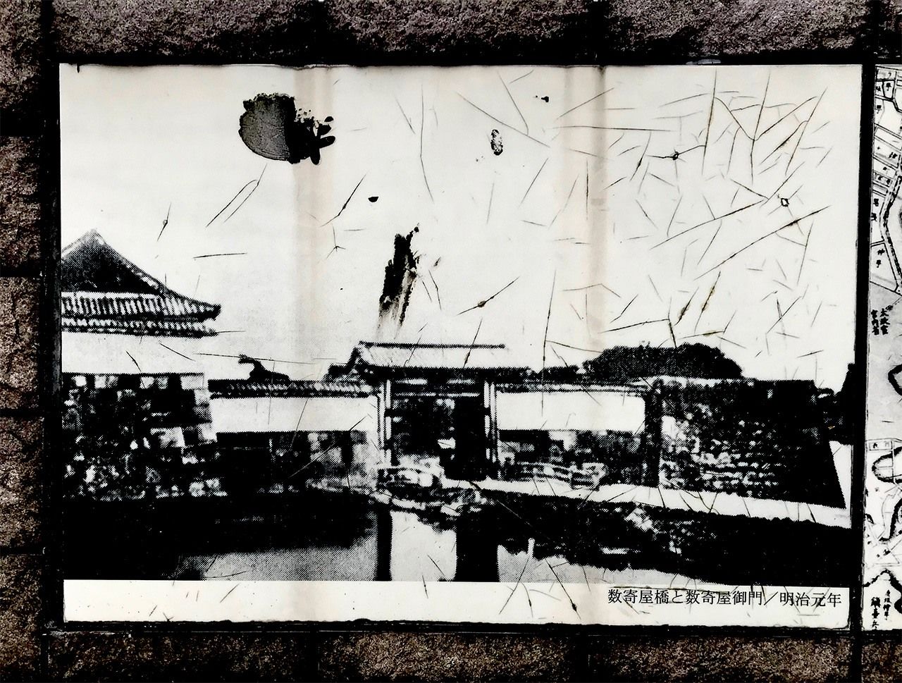 Une vieille photographie datée de la première année de l’ère Meiji, incrustée dans la chaussée de Harumi-dôri, montre le pont de Sukiya-bashi et sa porte fortifiée. (Photo prise par l’auteur)