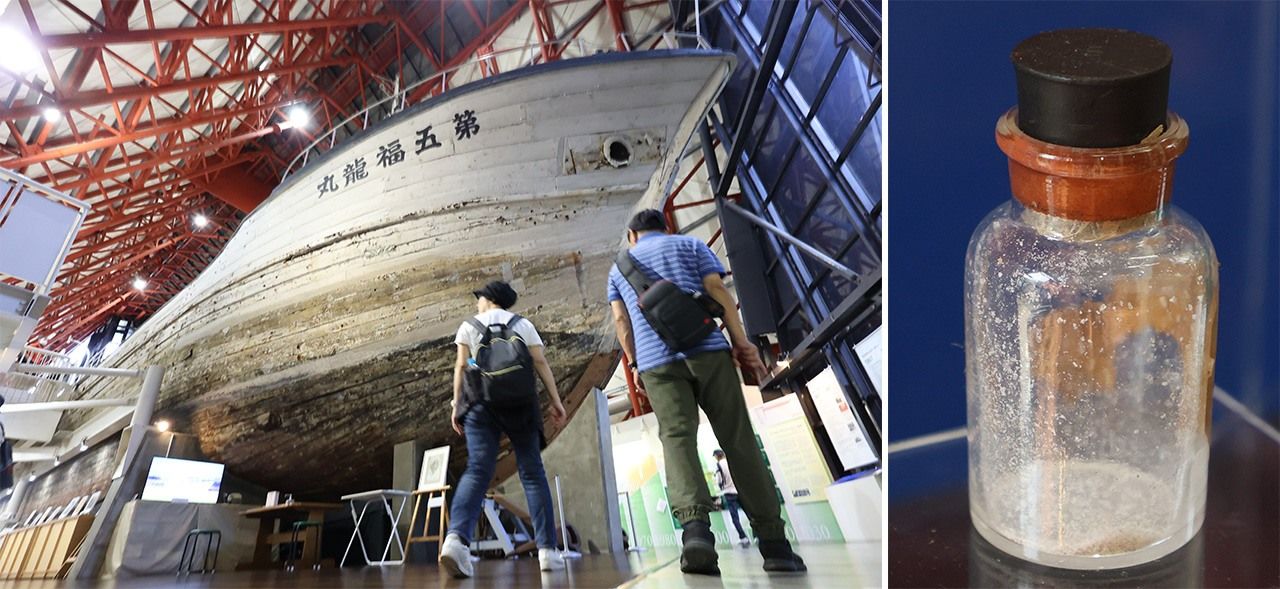 Le thonier Daigo Fukuryû Maru (Lucky Dragon No. 5), exposé au Daigo Fukuryû Maru Exhibition Hall à Tokyo, et une bouteille contenant les « cendres de la mort » recueillies sur le navire. Photos prises en juin 2024. (© Jiji)