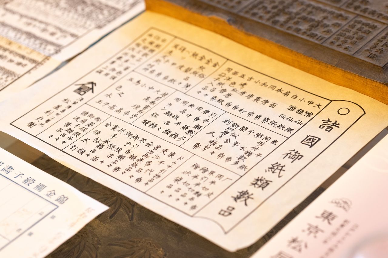 Un dépliant gravé sur un bloc de bois datant de l’époque d’Edo listant des catégories de produits papier. Une référence aux « nouvelles variétés de karakami » est faite dans l’encadré au centre à droite. (© Kawamoto Seiya).