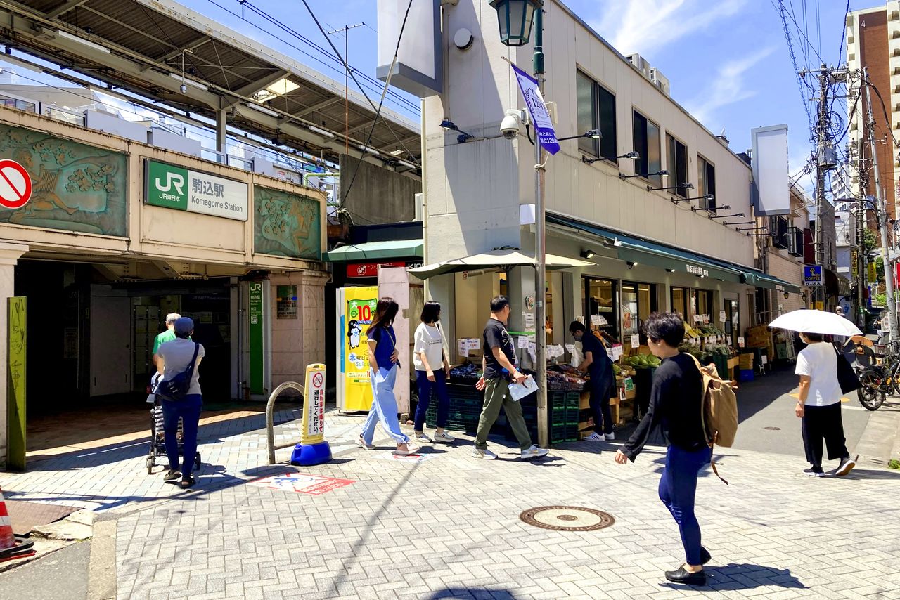 La rue commerçante animée devant la gare de Komagome
