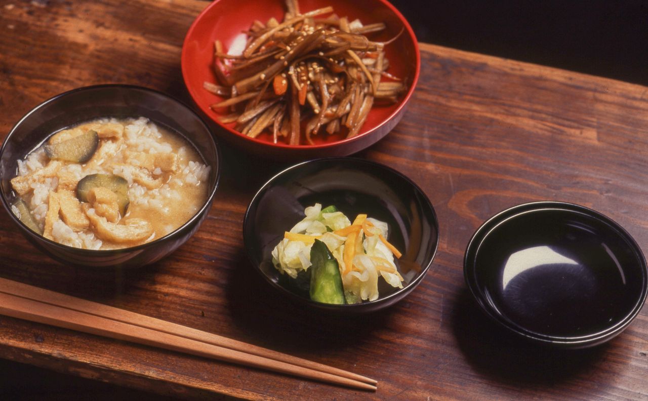 Un dîner : du grau de riz préparé à partir de restes du repas de midi, kinpira de racines de bardane et de carottes, et pickles. (© Harada Hiroshi)