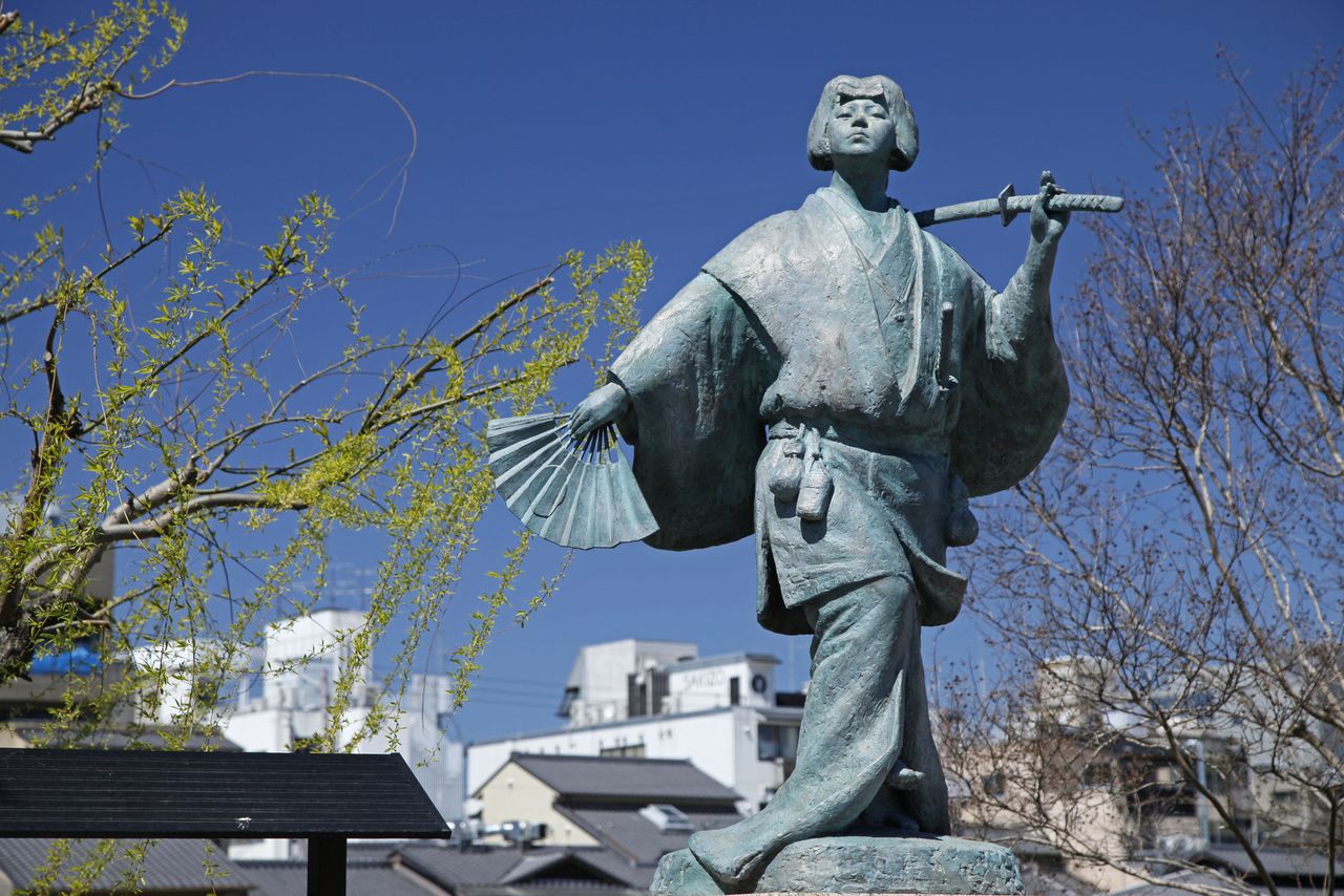 Cette statue d’Izumo no Okuni à Kyoto se trouve au bout du pont Shijô-ôhashi, à l’ouest du théâtre Minami-za, là où Okuni se serait produite lors d’une tournée de danses. Le sculpteur s’est inspiré du paravent « Okuni kabuki-zu », classé bien culturel important. (© Pixta)