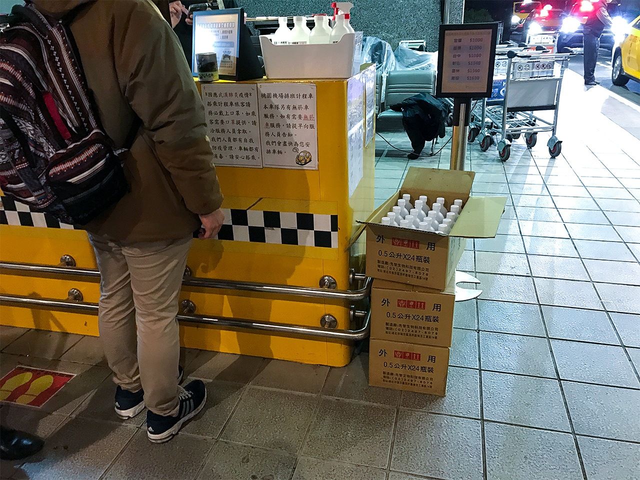 À la station de taxis de l’aéroport, des boîtes remplies de bouteilles de désinfectant hydroalcoolique sont prévues pour que les chauffeurs de taxi puissent désinfecter leur véhicule avant l’arrivée d’un nouveau passager.
