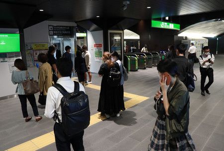 Des usagers attendant la reprise du trafic ferroviaire à la gare JR de Yûrakuchô le 7 octobre au soir.