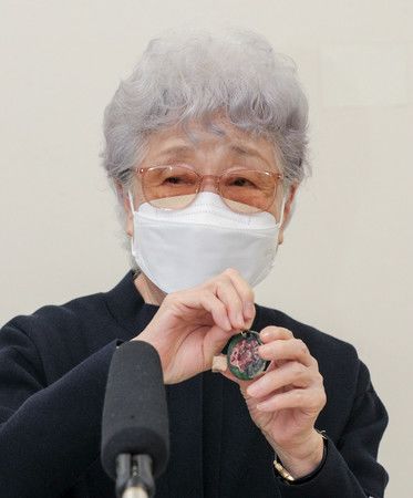 Yokota Sakie, le 9 juin, montrant un pendentif qu'avait fabriqué sa fille Megumi lorsqu'elle était écolière.