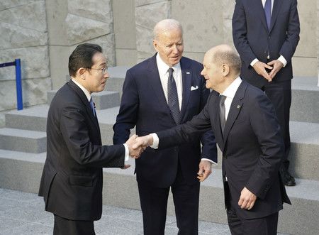 Kishida Fumio (gauche) serrant la main du chancelier allemand Olaf Scholz, en compagnie du président américain Joe Biden lors du sommet du G7 tenu à Bruxelles (24 mars).