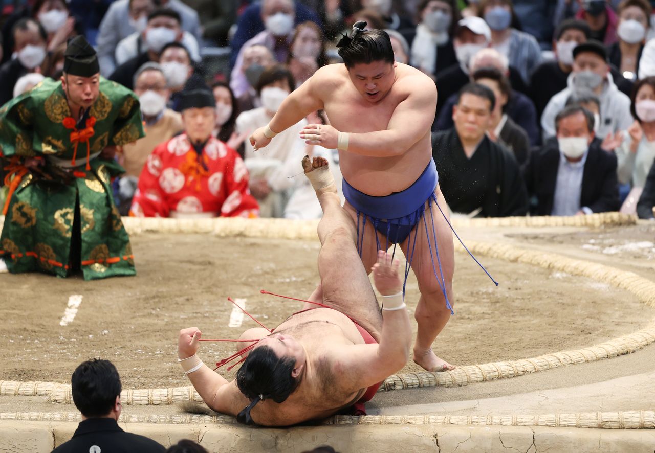 Wakatakakage assurant sa première place du tournoi de printemps en battant Takayasu grâce à un uwate-dashinage (technique consistant à tirer l'adversaire vers l'avant et le bas), à Osaka le 27 mars 2022 (Jiji Press).