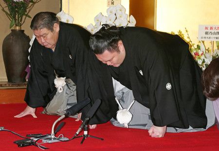 Le lutteur de sumo Asanoyama (à droite) s'incline en remerciement de sa promotion au rang de « Ozeki », avec à ses côtés Takasago, le chef de l'écurie auquel  il appartient.