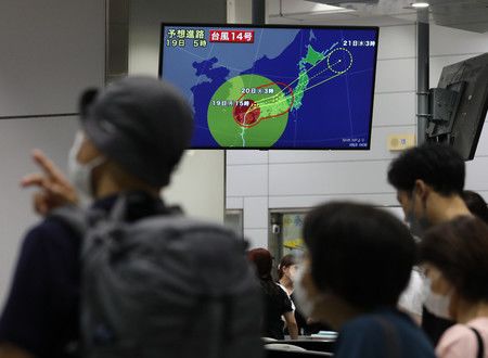 Des usagers du Shinkansen attentifs aux dernières infomations sur le typhon (le 19 septembre, gare de Shin-Osaka).