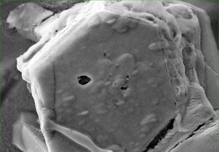 Grain de sable prélevé de l'astéroïde. De l'eau a été découverte dans la cavité au milieu.