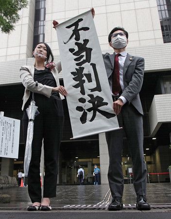 Les plaignants portant une bannière où il y est inscrit « Décision injuste », le 30 juin à Tokyo
