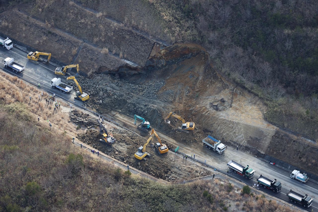 Opération de déblaiement sur l'autoroute Jôban à Sōma dans la préfecture de Fukushima, après qu'un tremblement de terre a provoqué un glissement de terrain, le 14 février 2021 (Jiji press). 