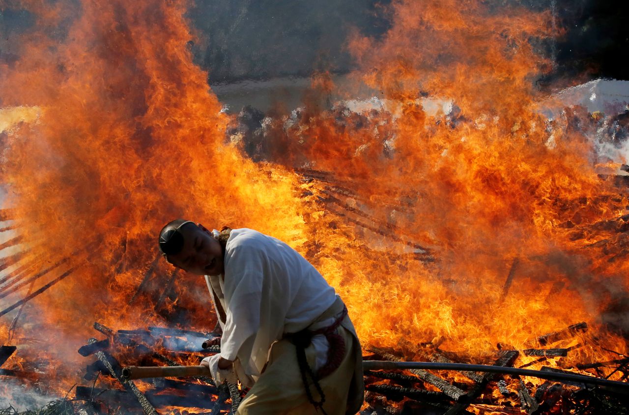 Les moines bouddhistes attisent les flammes d’un feu de joie lors du festival Hiwatari (au mont Takao le 14 mars 2021. REUTERS/Kim Kyung-Hoon)