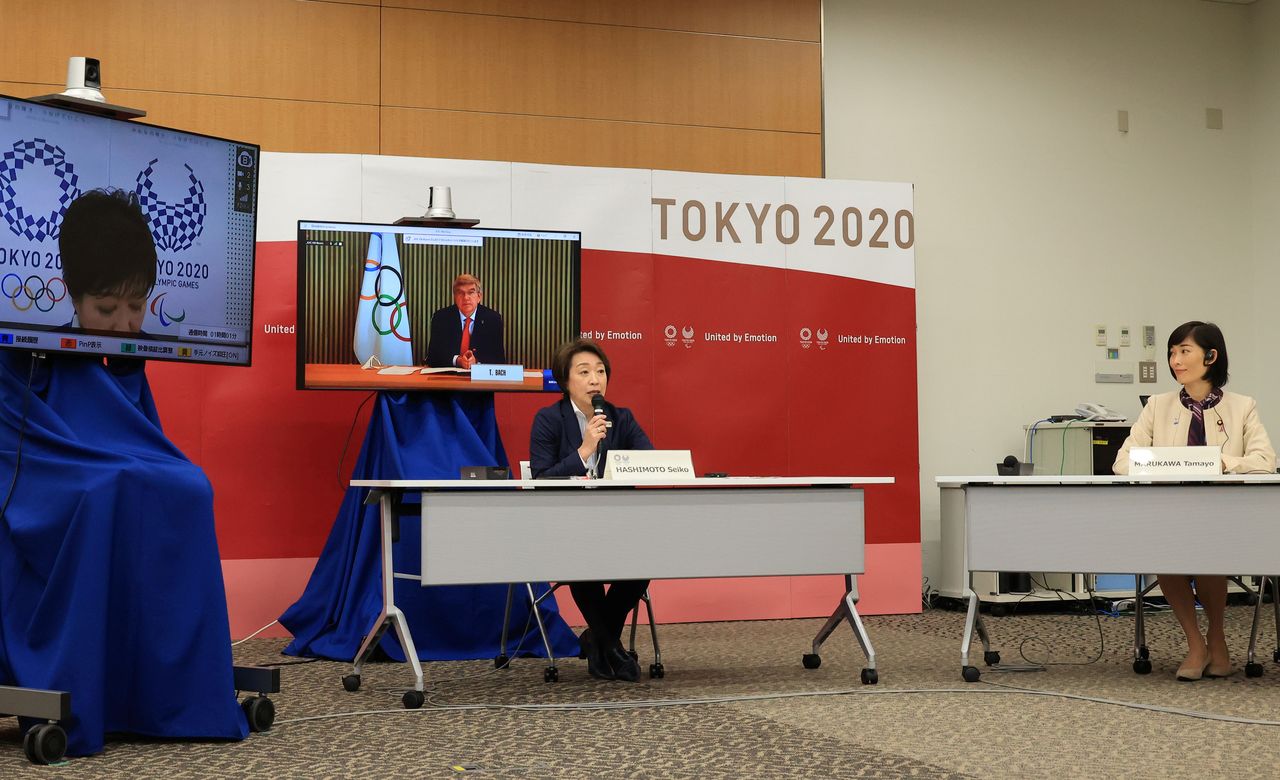 Hashimoto Seiko (au centre), présidente du Comité japonais d’organisation des Jeux olympiques et paralympiques de Tokyo, en vidéo-conférence avec Thomas Bach, le président du Comité international olympique, Koike Yuriko (à gauche), gouverneure de Tokyo, et Marukawa Tamayo (à droite), ministre en charge des Jeux olympiques et paralympiques (le 20 mars. Yoshikazu Tsuno/Pool via REUTERS).