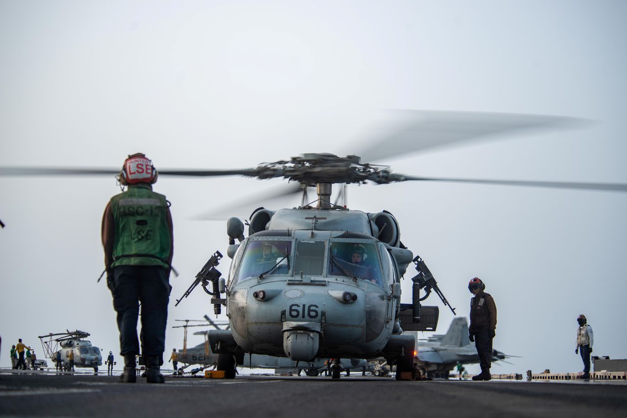 Des marins préparent un hélicoptère MH-60S Sea Hawk, attaché aux "Golden Falcons" de l