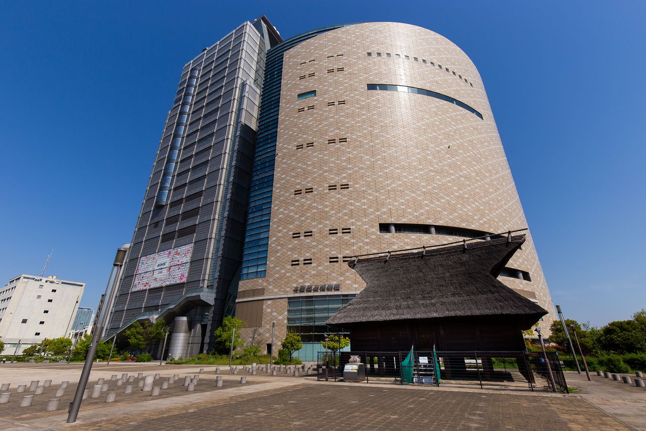 大阪歷史博物館和NHK大阪電視臺（左）連在一起。前面的茅草屋頂建築是復原後的法圓阪遺址倉庫
