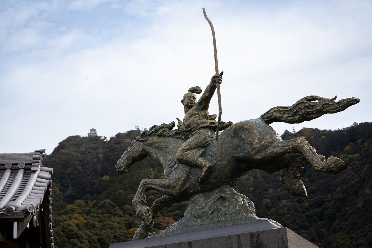 青年織田信長雕像聳立於岐阜公園入口處，背對岐阜城