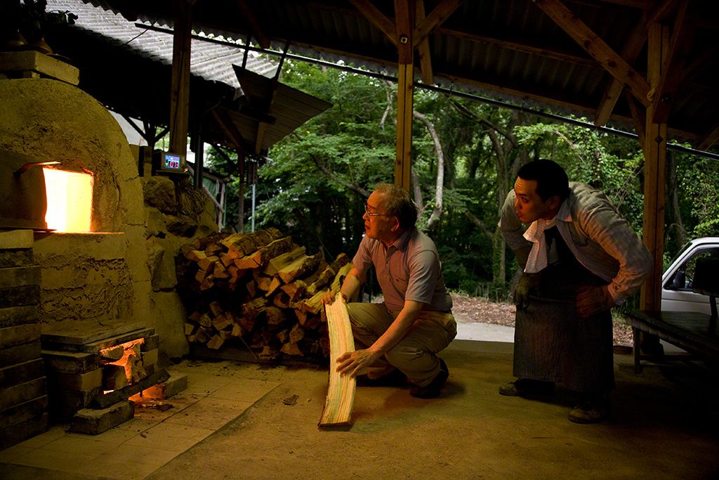 觀察窯中燒製情況的伊勢崎淳(左)