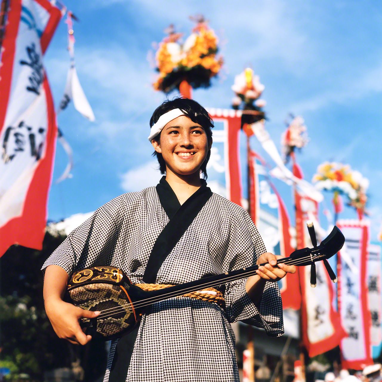 在石垣島的「豐年祭」上,手持三線琴的高中生