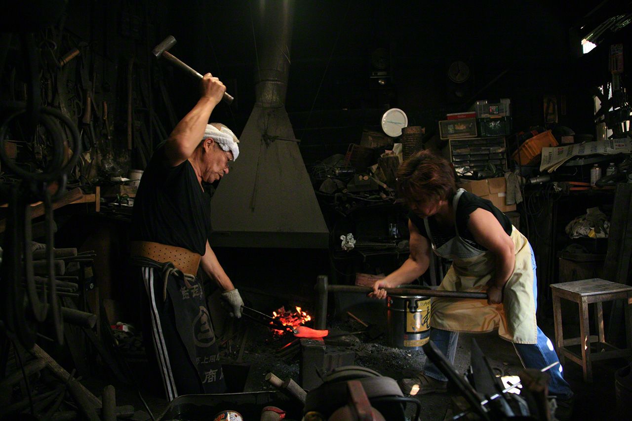 青森縣田子町的鐵匠中畑文利。他的妻子掄下沉重的錘子。這是被稱作「先手」的工藝