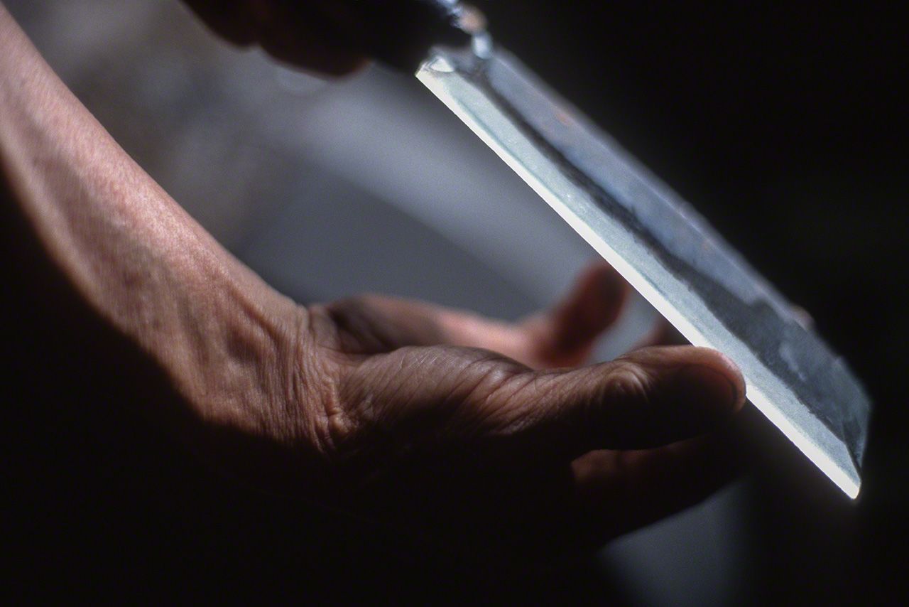 憑藉指尖觸感判斷刀刃鋒利程度的研磨作業。奈良縣十津川村田上鐵鋪的作坊