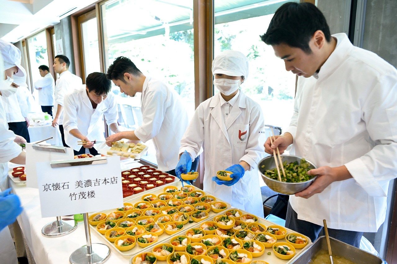 在日本料理實驗室，廚師和食品科學研究人員合作，每年都進行不同主題的烹調實驗。最右側為佐竹洋治（京都懷石料理美濃吉本店竹茂樓），正在為2017年研討會研究成果的展示準備供品嘗的料理（龍谷大學提供）