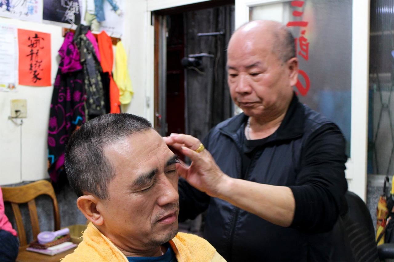 店長三郎先生正在為客人剃山本頭(筆者攝影)