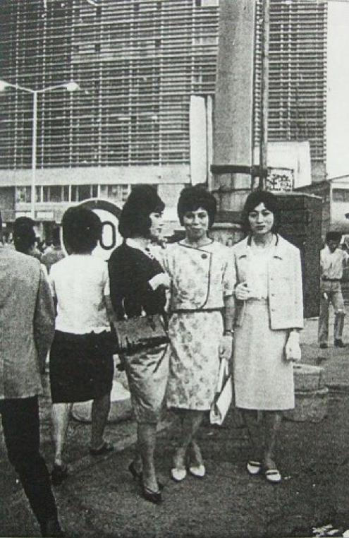 1964年6月,在外觀嶄新的新宿站東口大樓前拍照紀念,男扮女裝祕密結社「富貴俱樂部」的會員們。