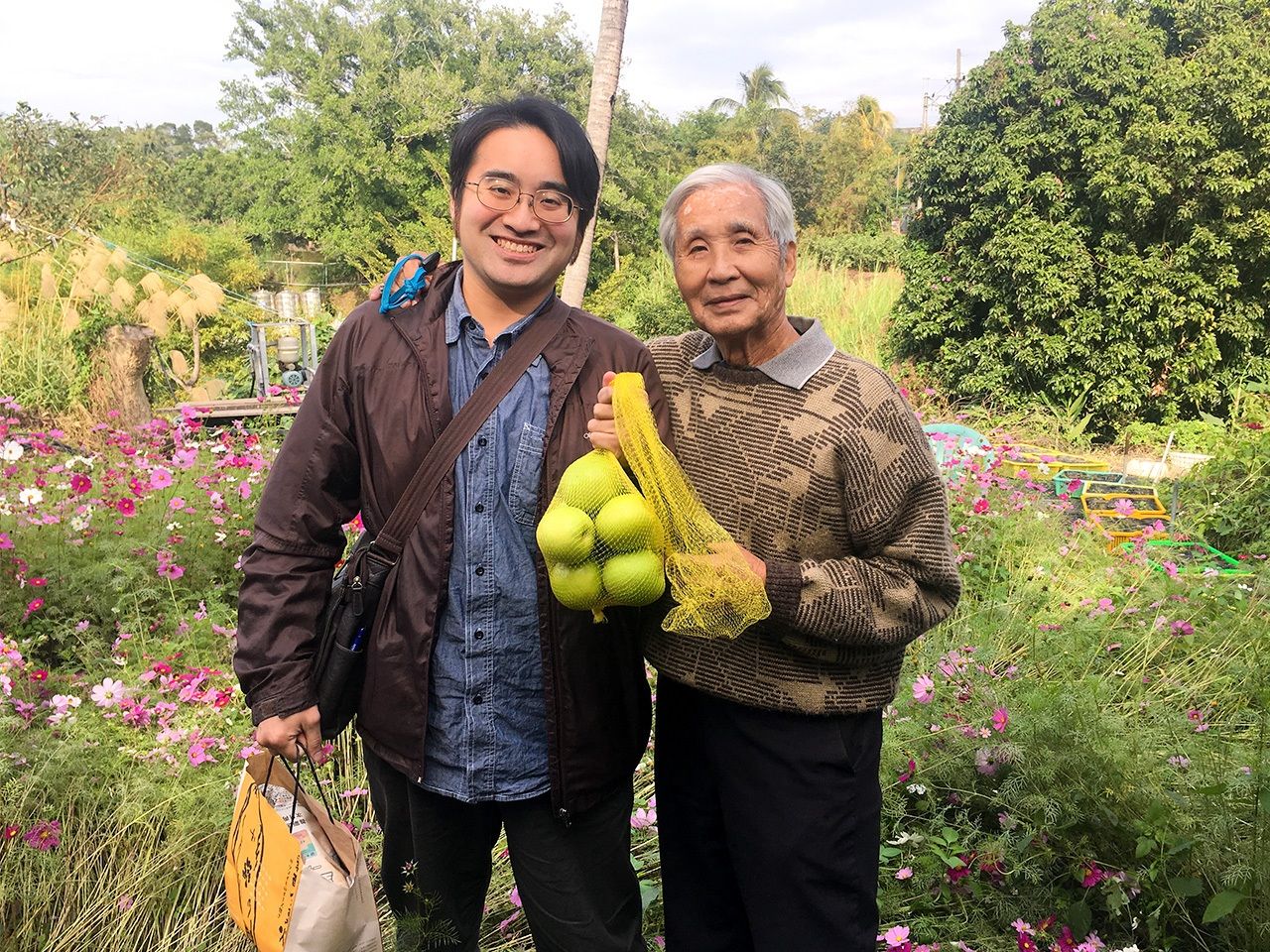 陳俊郎先生和筆者，手持的棗子為陳先生栽培的（筆者提供）