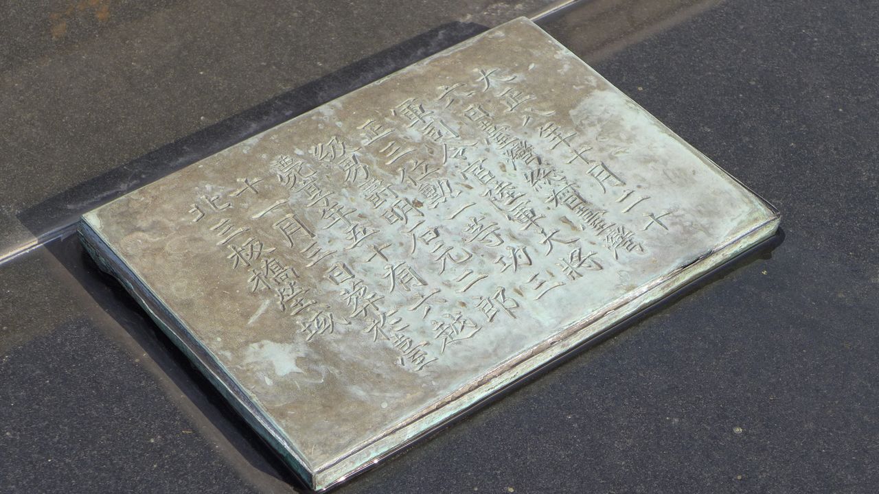 在三板橋墓園時的銅質碑牌也還在，跟棺木一起埋在地下（筆者攝影）