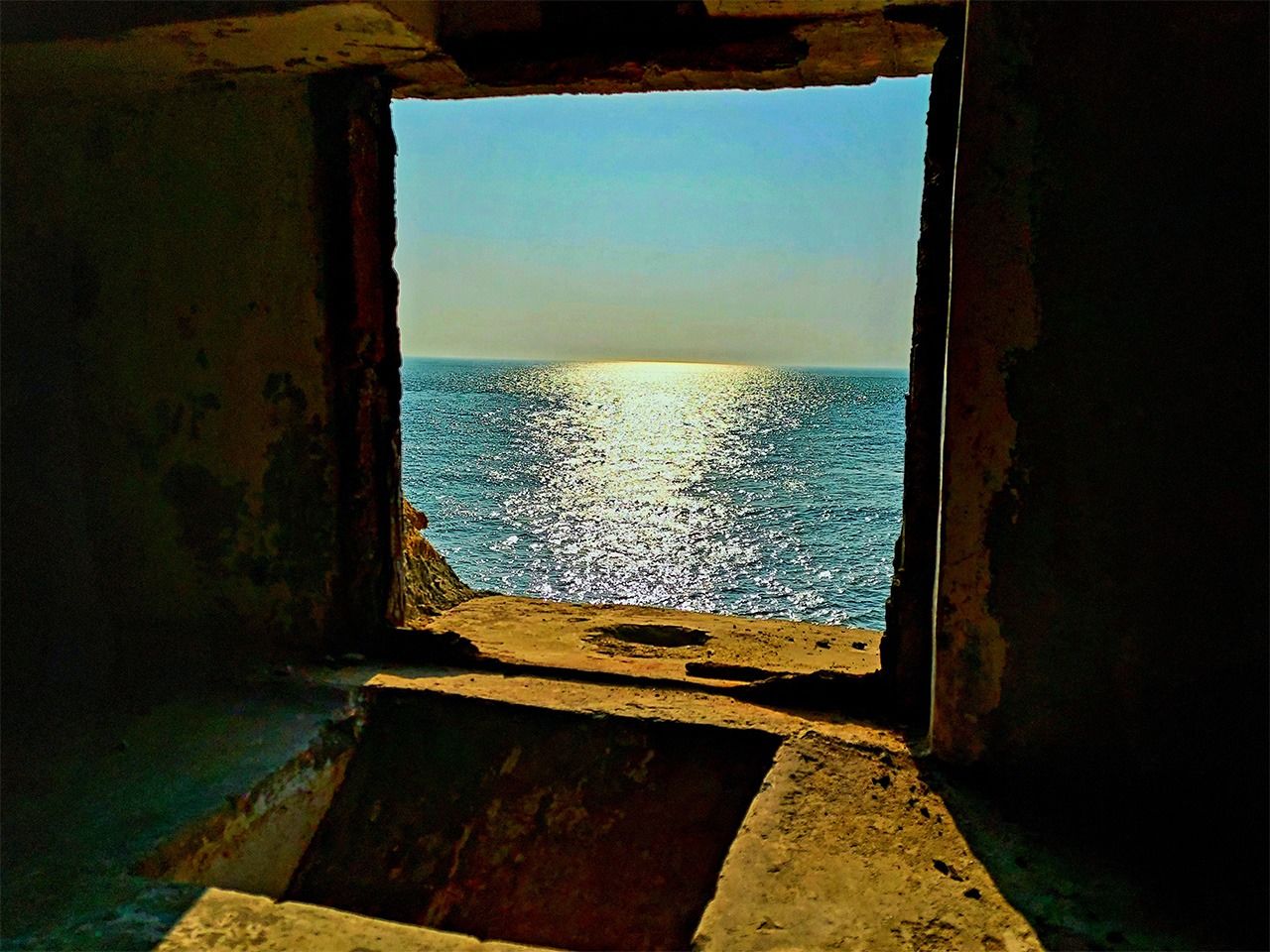 碉堡射撃口的另一頭，夕陽緩緩地沉入大海。