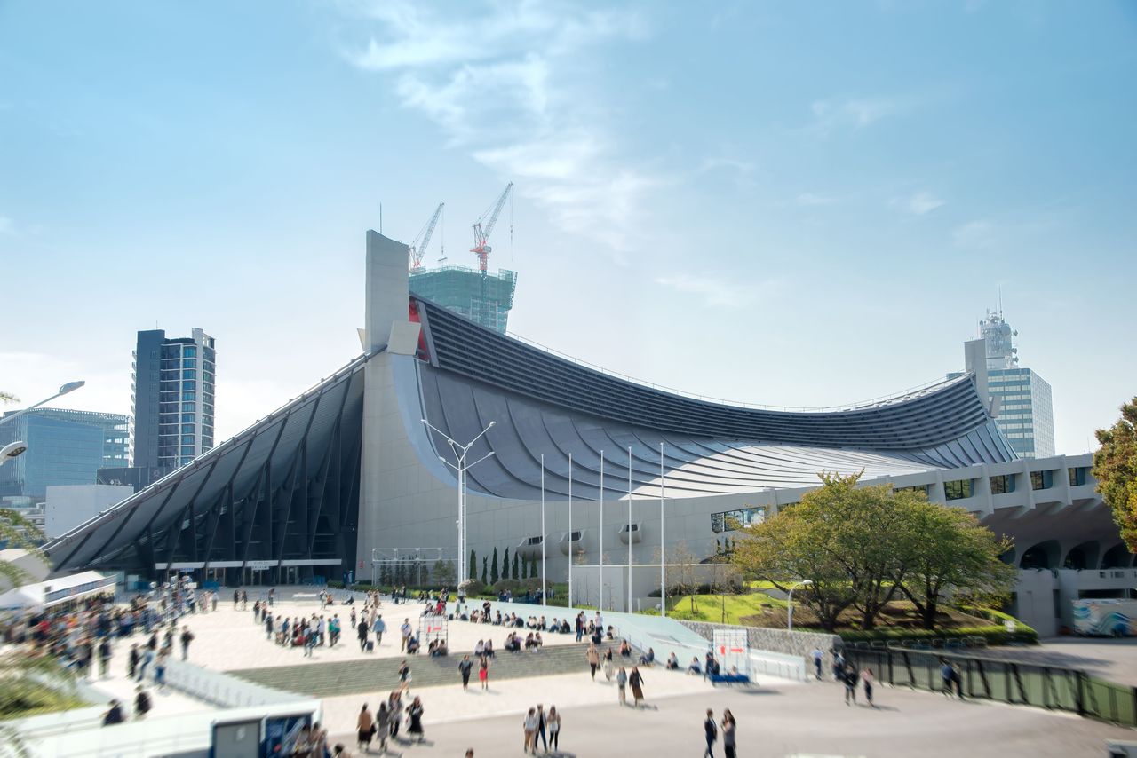 位於東京都澀谷區的國立代代木競技場第一體育館。位於澀谷坡道盡頭的山丘上，是一座以明治神宮守護林為背景的體育殿堂。1964年竣工（PIXTA）