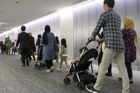 抵達成田機場,被日本政府列為撤退對象的阿富汗人們=19日、千葉縣成田市