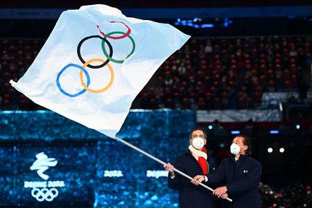 閉幕式上承接奧運旗的米蘭與科爾蒂納丹佩佐代表＝20日、北京（AFP時事）