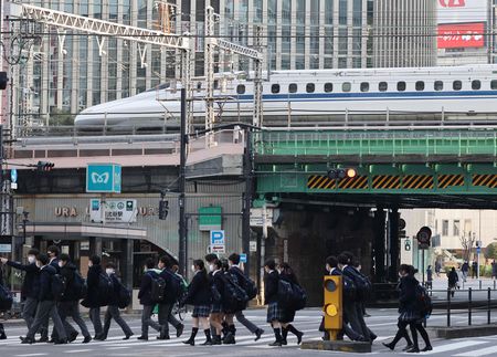 有樂町車站附近的高架體路上行走的新幹線與在十字路口交錯的行人＝1月26日、東京都