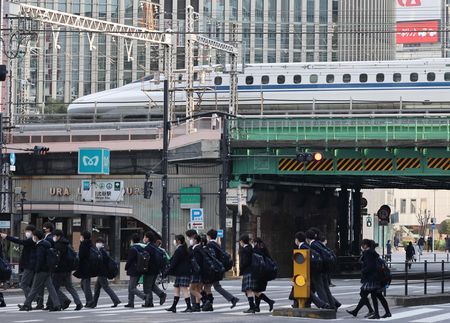 有樂町車站附近的高架體路上行走的新幹線與在十字路口交錯的行人=1月26日、東京都