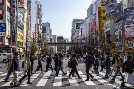 在東京秋葉原十字路口步行的人們＝24日、東京都内（AFP時事）