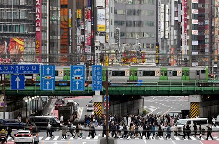 新宿車站附近的JR高架橋下，於十字路口行走的人們＝29日、東京都新宿區（EPA時事）