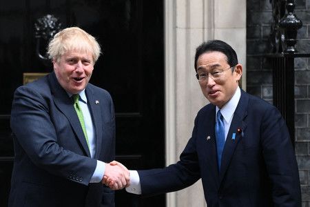 在會談前相互握手的首相岸田文雄（右）與英國首相強生＝5日、倫敦（AFP時事）