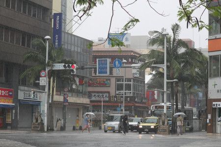 沖繩回歸50週年的早上、雨中於國際通交錯漫步的行人們與十字路口＝15日上午、那霸市