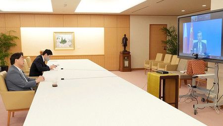 與中國國務委員兼外交部長王毅舉行電視會談的外務大臣林芳正(左)=18日上午、於外務省(同省提供)