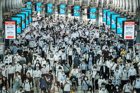 在東京的車站走廊內徒步的通勤客＝2021年7月（AFP時事）