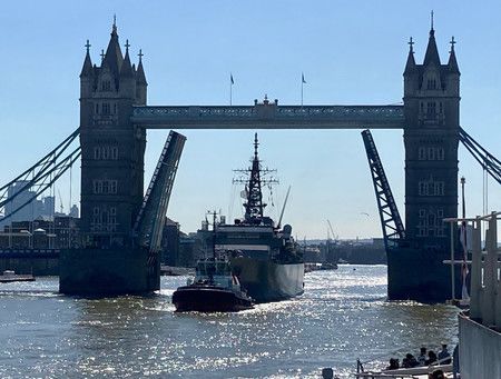 從泰唔士河上的倫敦鐵橋經過的海上自衛隊練習艦「鹿島」（中央）＝22日、倫敦