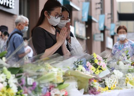 在前首相安倍晉三被槍殺的現場附近設置的花壇上，人們相繼合掌追悼＝15日上午，奈良市