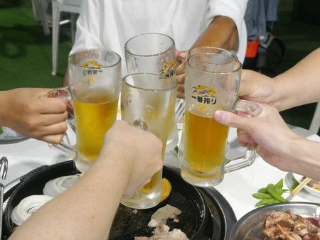 在明治神宮外苑内「森林啤酒花園」內乾杯的公司職員們＝22日、東京都新宿區