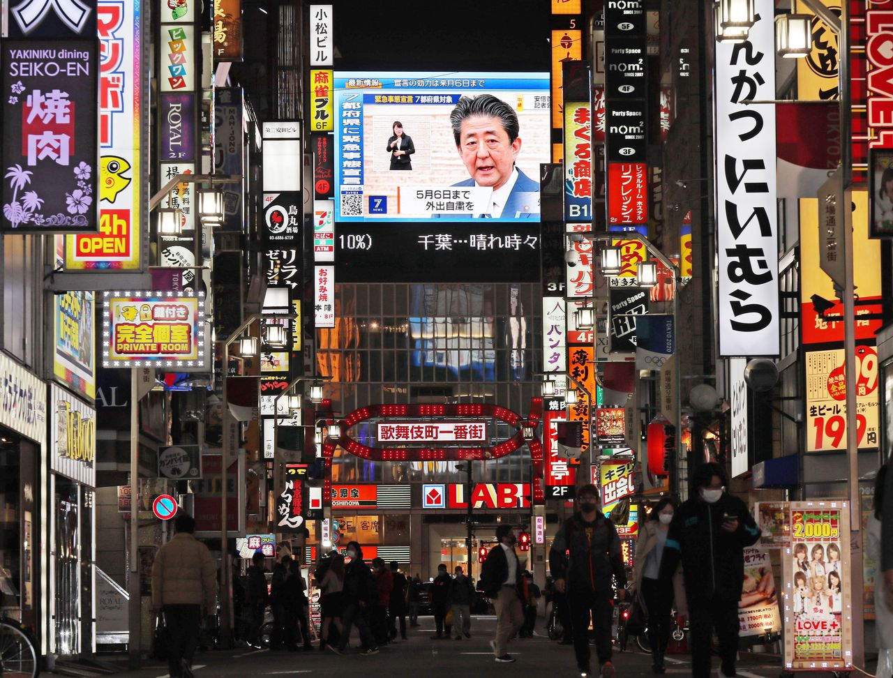 東京歌舞伎町街頭的大螢幕上，播放正在召開記者會的日本首相安倍晉三（4月7日晚、東京都新宿區）